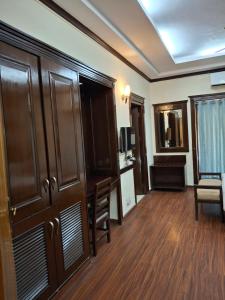 a room with a large wooden cabinet and a desk at Hotel Siris 18 in Gurgaon