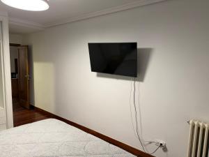 ein Flachbildfernseher an der Wand eines Schlafzimmers in der Unterkunft D&L 3 piso compartido in Vigo
