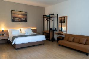 a hotel room with a bed and a couch at Anamcara Hotel & Convention in Cipanas