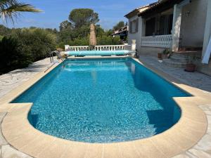 a swimming pool with blue water in front of a house at Lac Saint Esprit in Fréjus