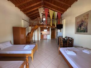 a living room with two beds and a staircase at Rexhos Studios in Himare