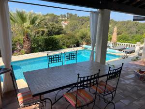 a patio with a table and chairs next to a swimming pool at Lac Saint Esprit in Fréjus