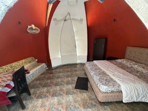 two beds in a room with red walls at Infinity Farm Grove in Olavakod Junction