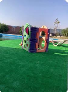 a playground with a slide on the grass at Blue Escape in Oulad Teïma