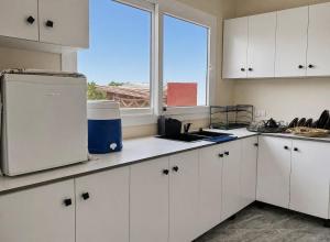 a kitchen with white cabinets and a window at Blue Escape in Oulad Teïma