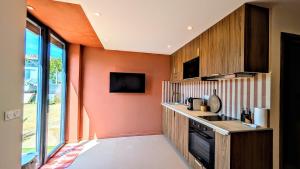 a kitchen with an orange wall and a sink at LA BRISA Duplex chaleureux in Hyères +13 photos