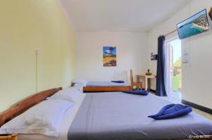 two beds in a white room with a window at VaoVao Hotel in Nosy Be +34 photos