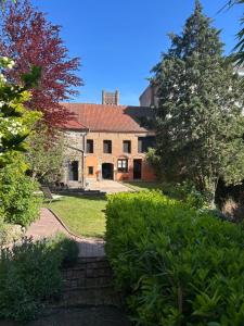 a house with a yard with trees and bushes at La suite Isabelle de Luxembourg in Béthune
