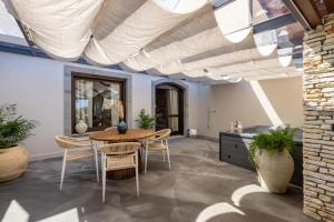 a dining room with a table and chairs under a ceiling at Cocciu D'Amuri in Mongiove