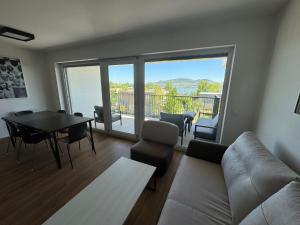 a living room with a couch and a table and chairs at Apartmány Římský vrch s úžasným výhledem na Pálavu in Pasohlávky