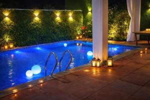 a swimming pool at night with lights around it at Aadhya Hotel & Adhira Restaurant in Orchha +11 photos