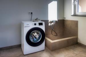 a washing machine in a bathroom with a shower at Bayerwald-Bungalow in Grattersdorf