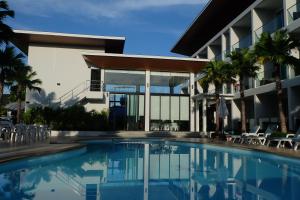 a large swimming pool in front of a large building at Clear House Resort - SHA Extra Plus in Kamala Beach