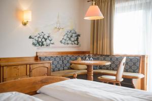a hotel room with a table and a couch at Hotel Rochushof in Schenna