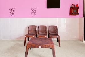 two chairs and a stool in front of a wall at Spot On Moonlight Hotel in Jhajjar