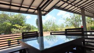 a glass table on a porch with two chairs at wild elephant reach wilpaththuwa in Nochchiyagama