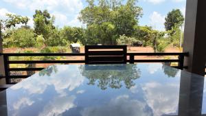 a bench sitting on a table with a reflection of the sky at wild elephant reach wilpaththuwa in Nochchiyagama