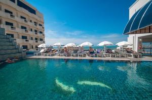 una piscina frente a un hotel en Flipper House Hotel - SHA Extra Plus en Pattaya centro