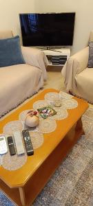 a coffee table in a living room with a tv at Panos House - Warm and cozy retreat in Tríkala