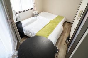 a room with a bed and a chair in it at Ijiri Relax stay in Fukuoka