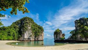 a beach with rocks in the water and a beach with people on it at Z-Talay House in Klong Muang Beach