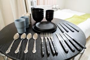 a table with utensils on a black table at Ijiri Relax stay in Fukuoka