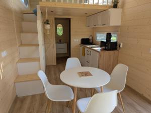 a kitchen and dining room of a tiny house with a table and chairs at Les Nids de Cerisy in Cerisy-la-Forêt