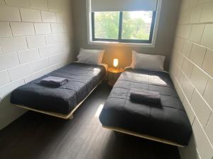 zwei Einzelbetten in einem Zimmer mit Fenster in der Unterkunft McInnes Units in Naracoorte