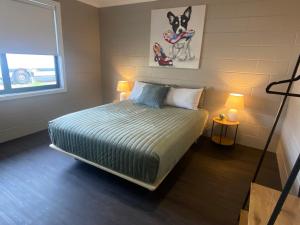ein Schlafzimmer mit einem Bett und einem Hundebild an der Wand in der Unterkunft McInnes Units in Naracoorte