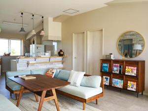 a living room with a couch and a table at GuesthouseKAZE in Miyako-jima