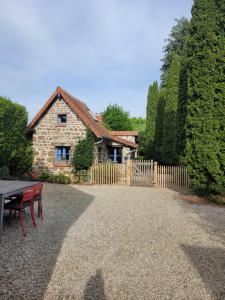 a stone house with a picnic table and a fence at Domaine Bel Air 855 - Gîte Belle in Saint-Denis-de-Villenette