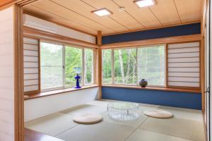 a room with windows and a table and stools at S-villa那須Audrey in Nasu