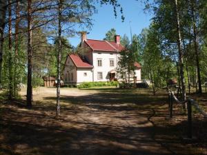 ein großes weißes Haus mitten in einem Wald in der Unterkunft Maininki in Sulkava