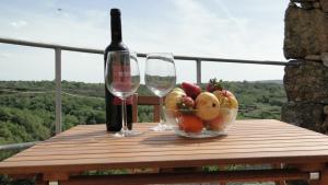 a table with two wine glasses and a bowl of fruit at Casinha Das Portas in Castelo Bom +19 photos
