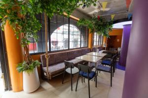 a restaurant with a bench and tables and chairs at Hotel Rue De Siam in Chinatown