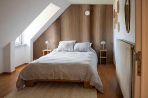 a bedroom with a bed with a wooden headboard at Rouges Terres in Theux