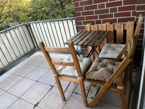 a wooden chair and a table on a balcony at Private Room in Oldenburg with Balcony in Shared Apartment in Hundsmühlerhöhe