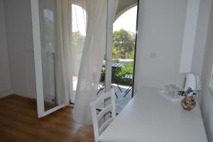 a white room with a white chair and a mirror at Black and White Spacious Apartment in Hvar