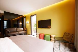 a bedroom with a bed and a tv on a yellow wall at MD HOTEL Dongtan in Hwaseong