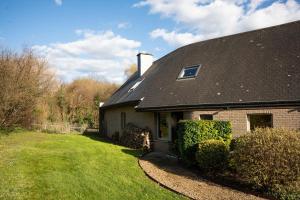 a house with a black roof and a yard at Rouges Terres in Theux