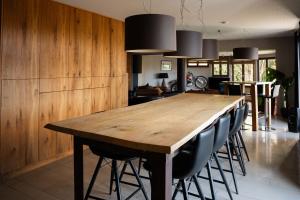 a dining room with a wooden table and chairs at Rouges Terres in Theux