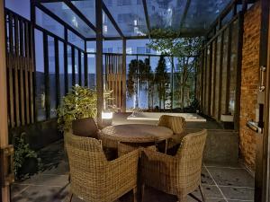a patio with a table and wicker chairs at MD HOTEL Dongtan in Hwaseong