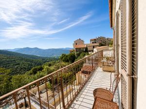 a balcony with chairs and a view of the mountains at Hôtel Villa Les Orangers in Olmeto