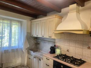 a kitchen with white cabinets and a stove top oven at Casa nonna Bruna in Montebruno