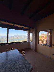 a dining room with a table and two windows at Casa Vacanze Panoramika Santa Cruz - Appartamento PANORAMIKA in Cicerale +5 photos