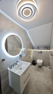 a bathroom with a white sink and a mirror at Noclegi Ewelina in Nowa Ruda +8 photos