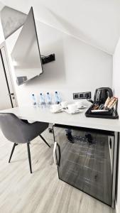 a white desk with a chair and glasses on it at Noclegi Ewelina in Nowa Ruda