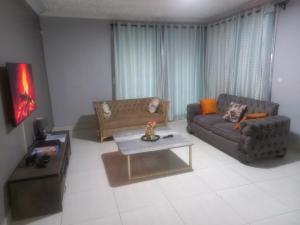 a living room with two couches and a coffee table at Alamaison in Umtali