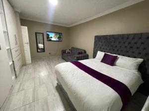 a bedroom with a large bed and a chair at Alamaison in Umtali