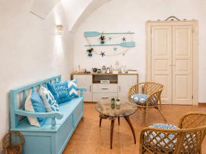 a living room with a blue couch and a table at Casa Chicchella - Authentic Experience in Vieste